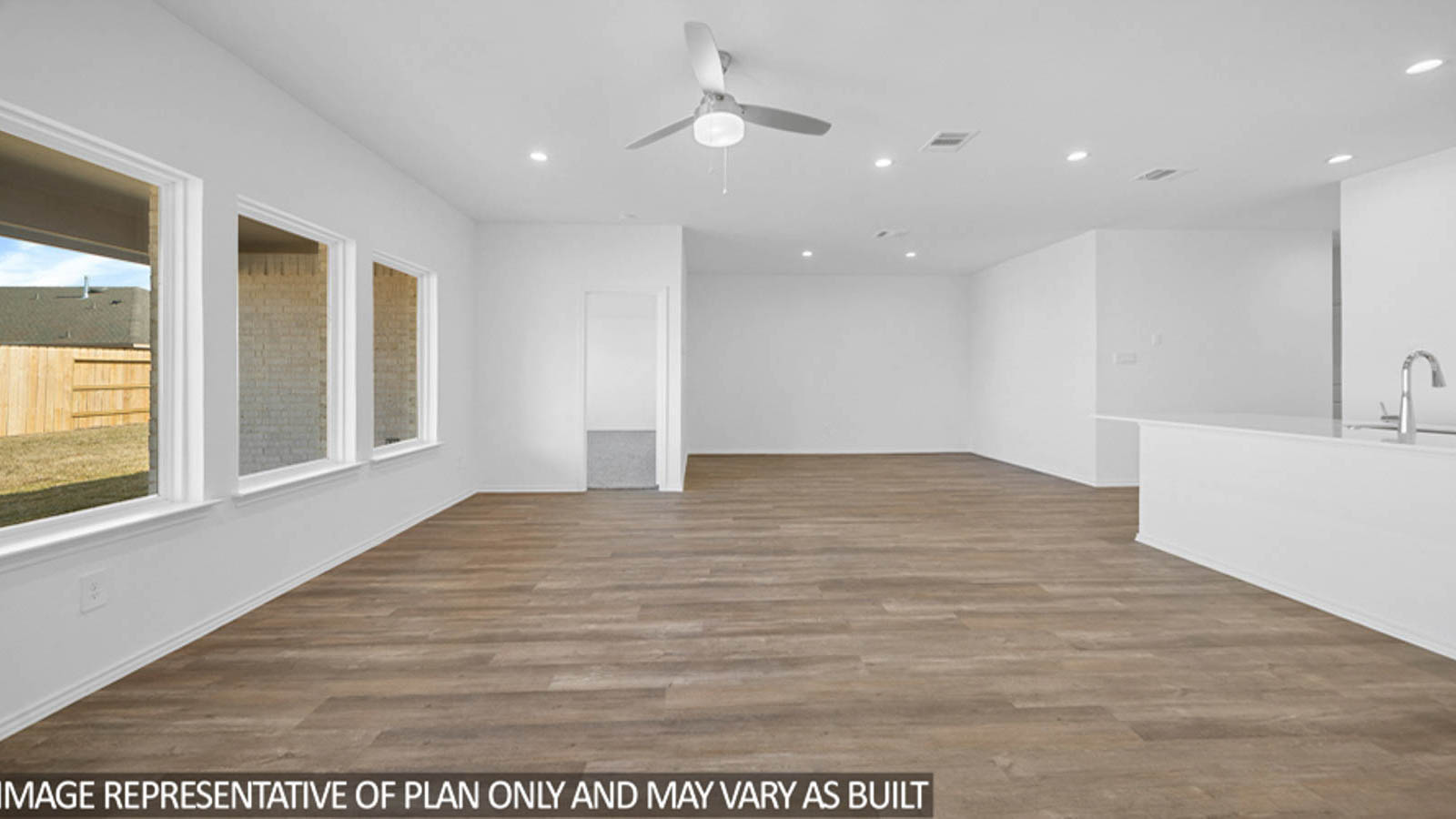 open cncept living and dining area with vinyl flooring, large windows, and quartz countertops in Katy, TX