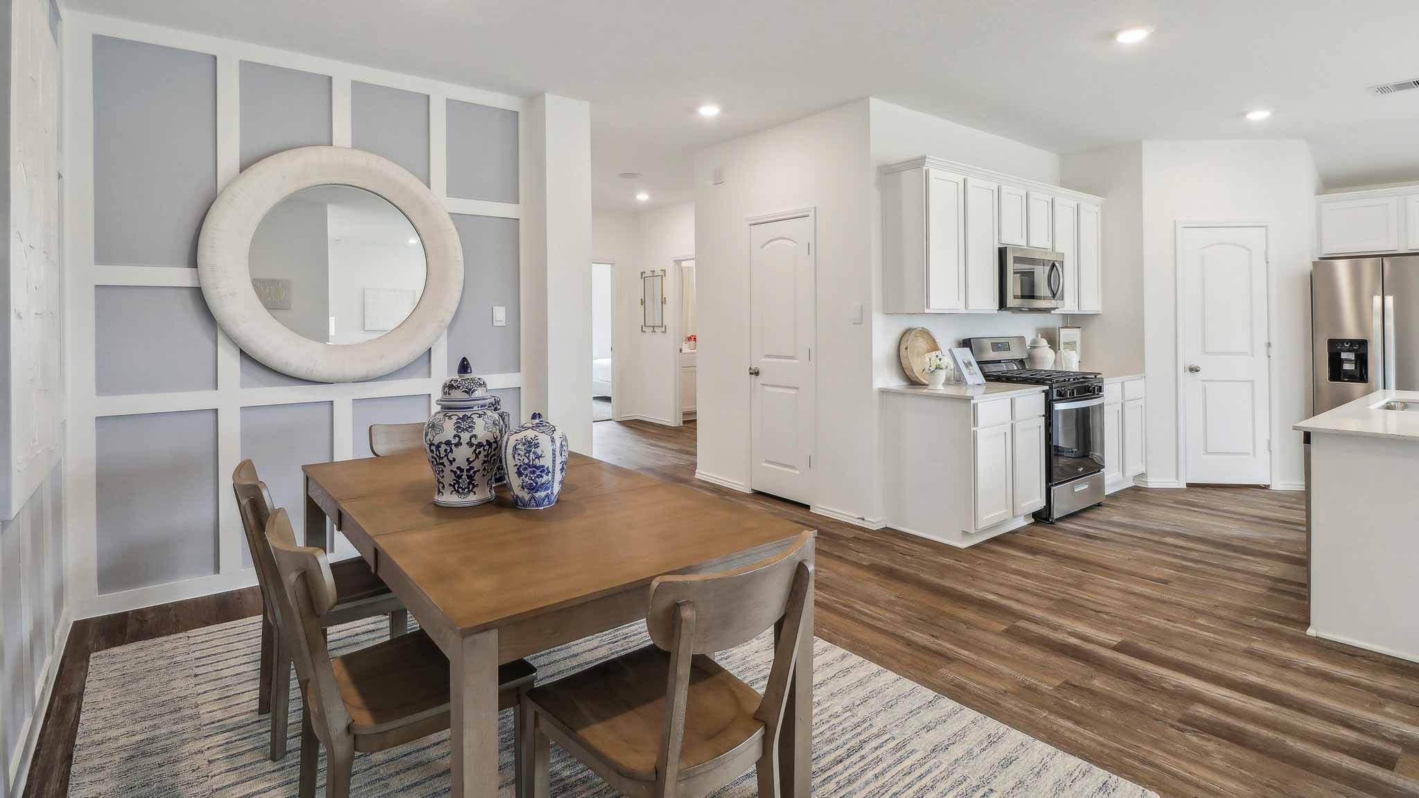 open concept living and dining area with vinyl flooring, quartz counertops, and large widows