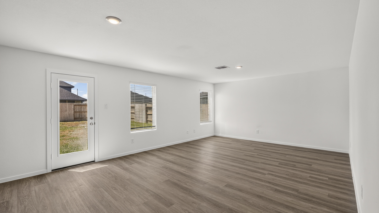 open concept living and dining area with vinyl flooring, quartz countertops, and stainless steel appliances