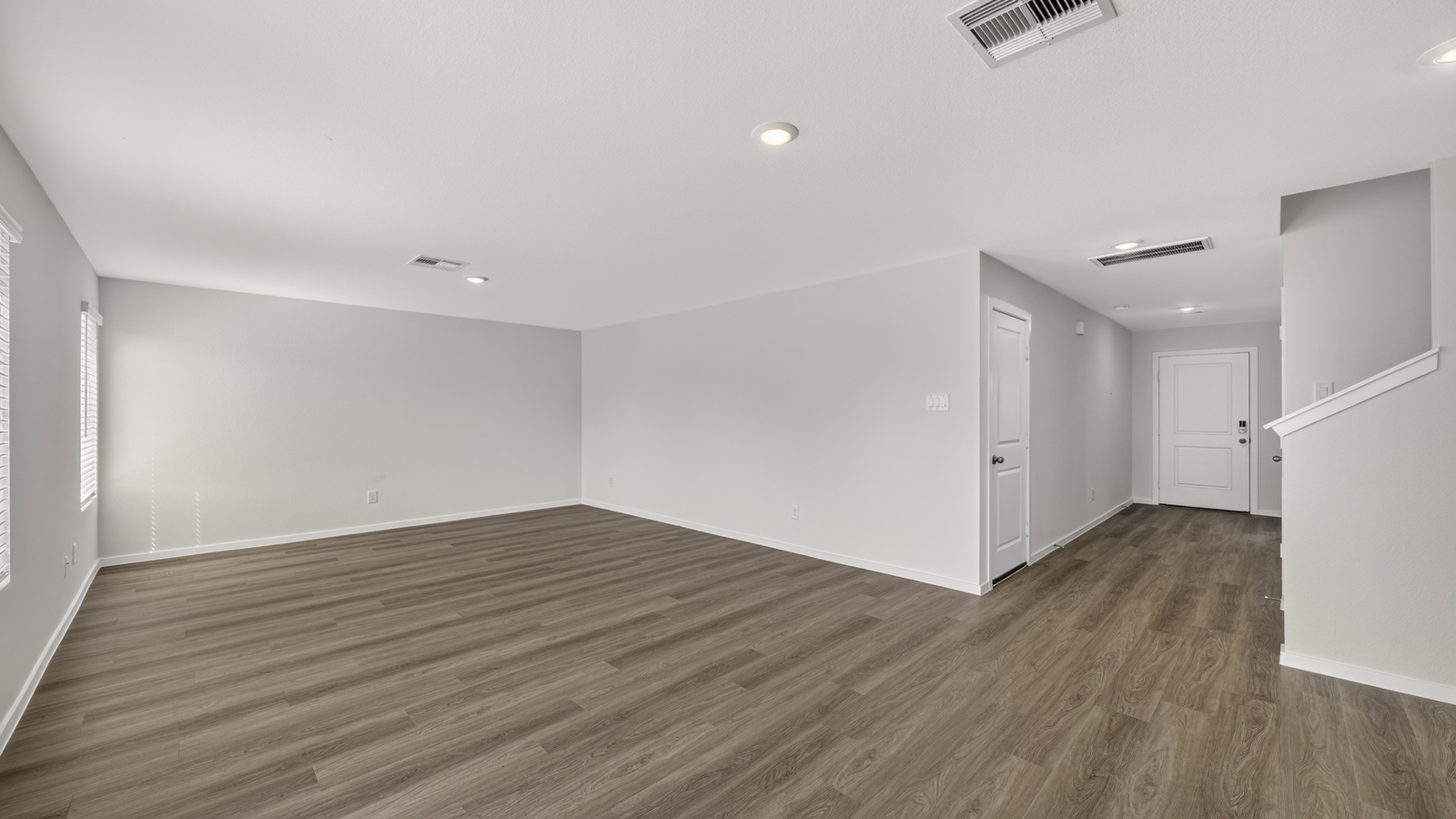 open concept living and dining area with vinyl flooring, quartz countertops, and stainless steel appliances