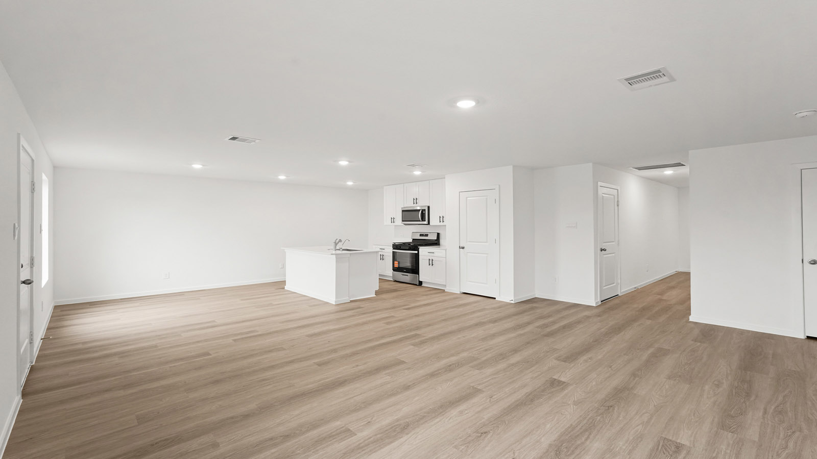 open concept living and dining area with vinyl flooring, quartz countertops, and large windows