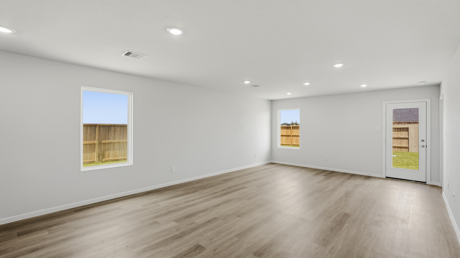 open concept living nd dining area with vinyl flooring and large windows in Katy, TX