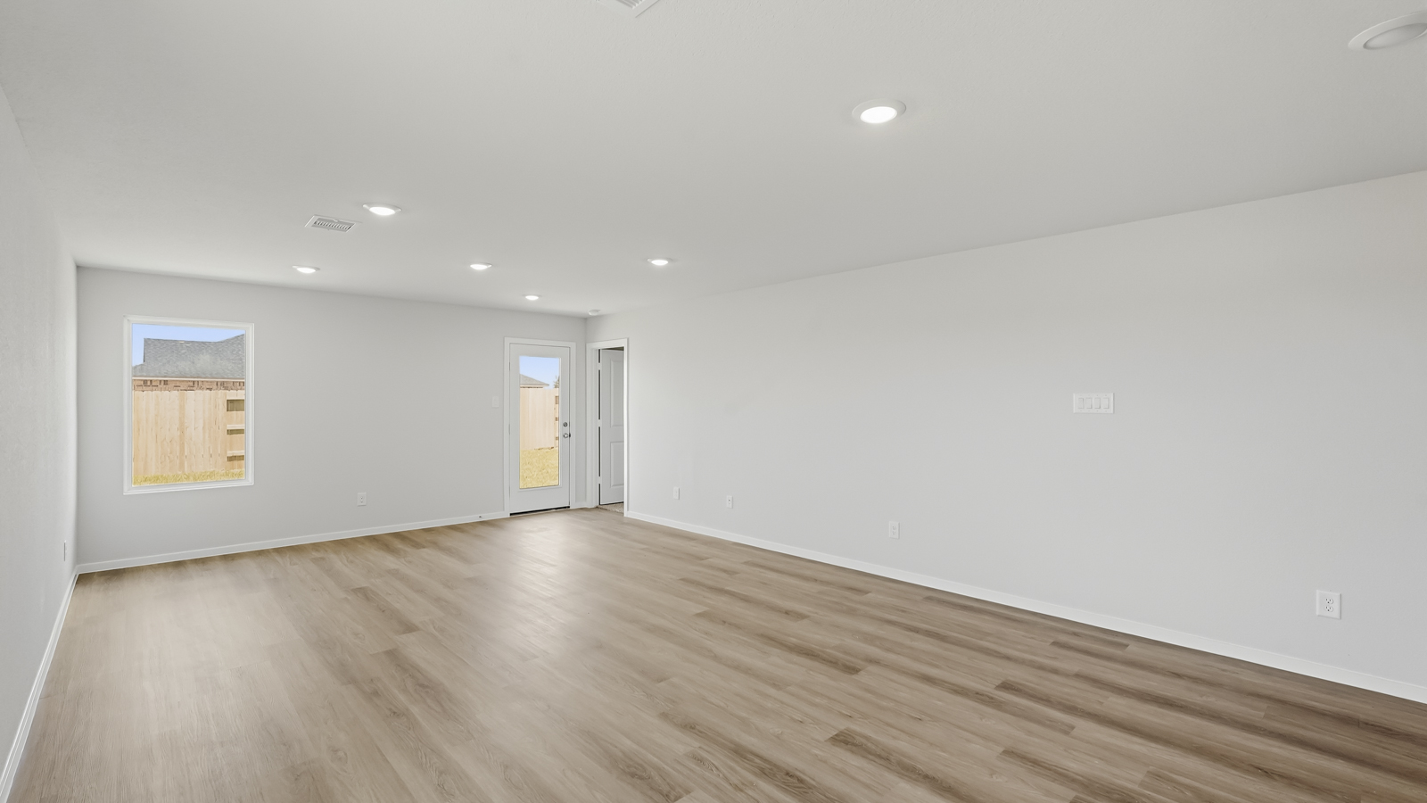 open concept living nd dining area with vinyl flooring and large windows in Katy, TX