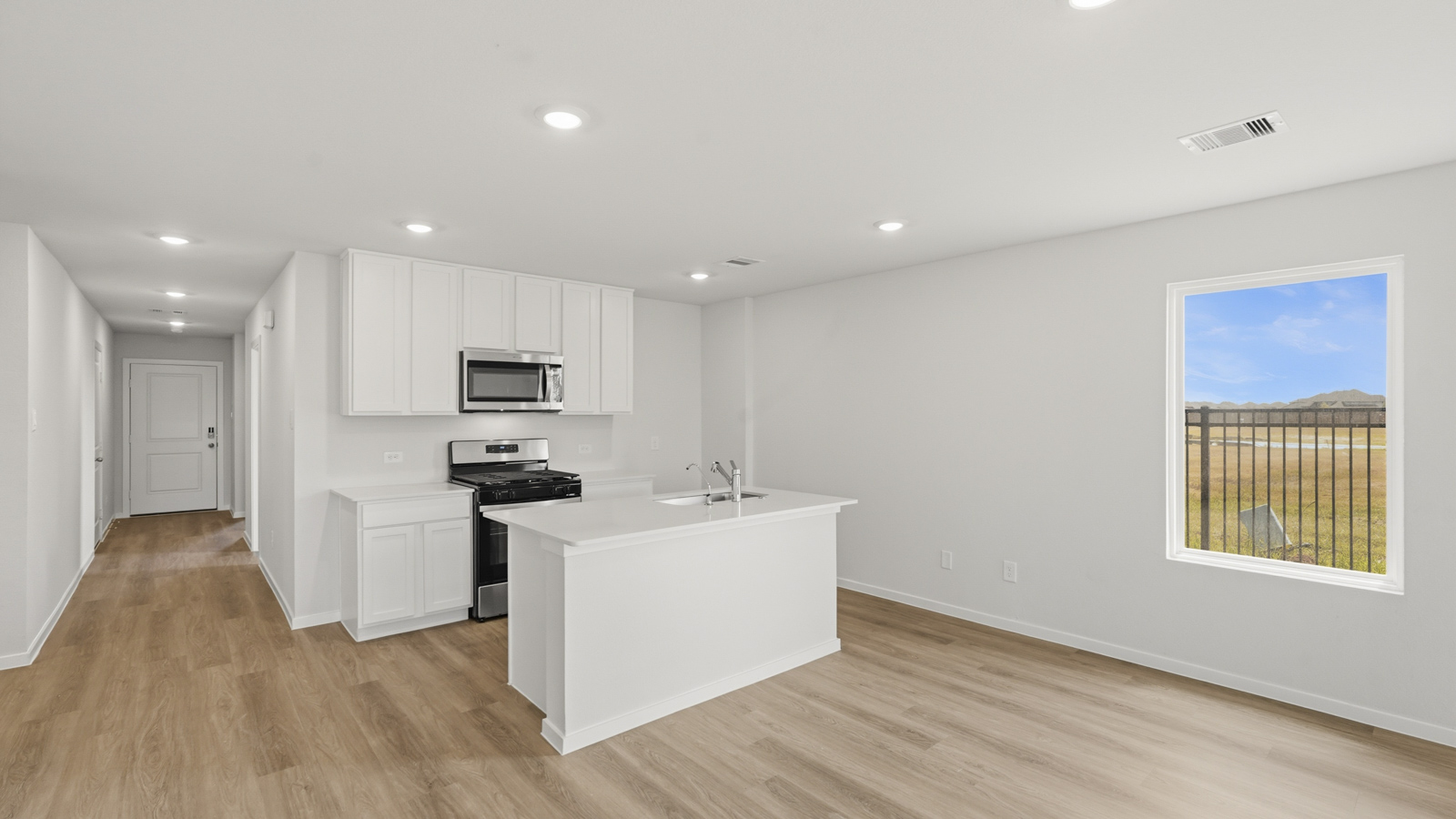 open concept living and dining area with vinyl floorin, quartz countertops, and large windows