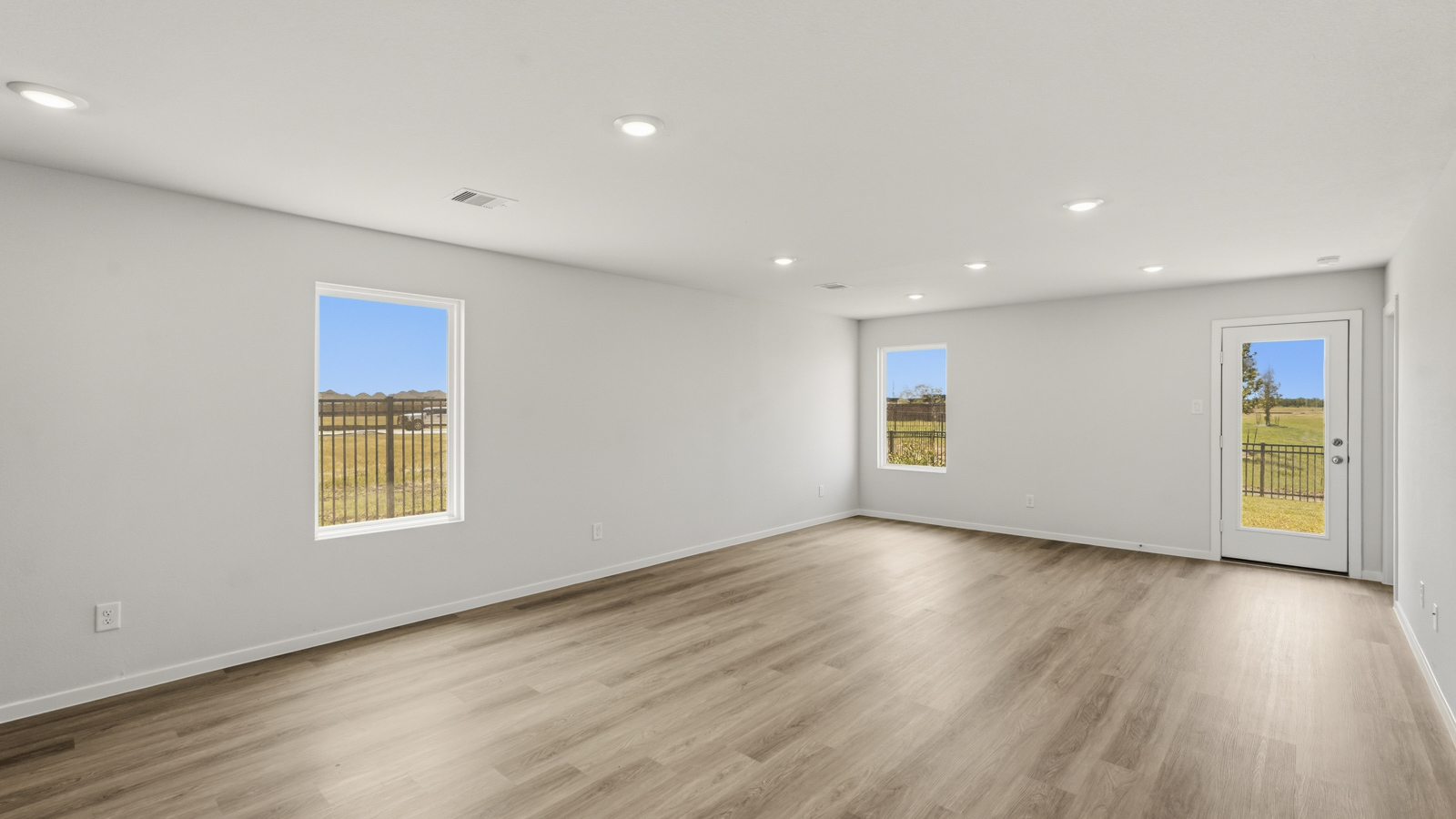 open concept living and dining area with vinyl floorin, quartz countertops, and large windows