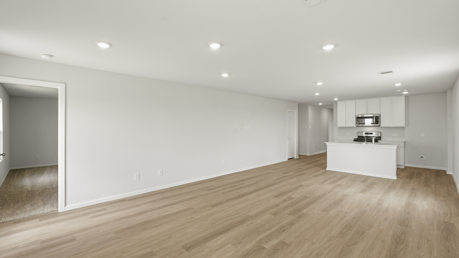 open concept living and dining area with vinyl floorin, quartz countertops, and large windows