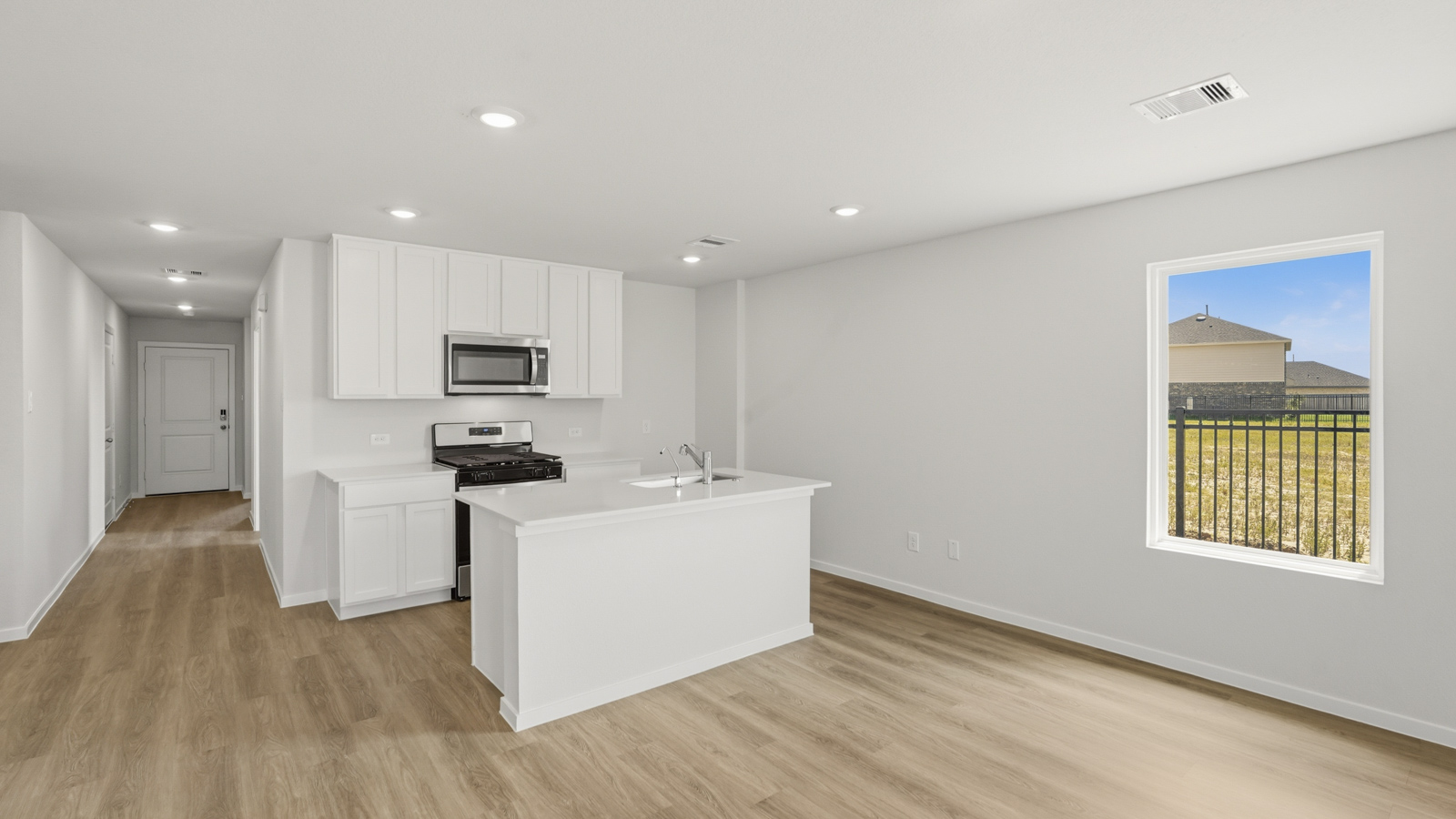 open concept living and dining area with vinyl flooring, stainless steel appliances, and quartz countertops in Katy, TX