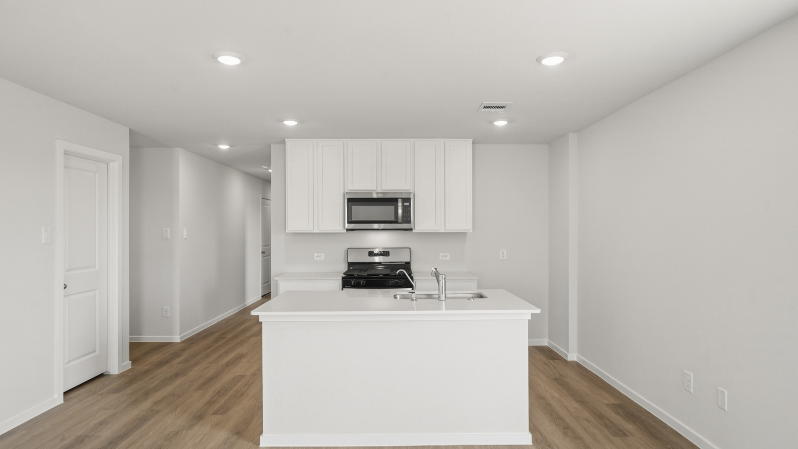 open concept living and dining area with vinyl flooring, stainless steel appliances, and quartz countertops in Katy, TX