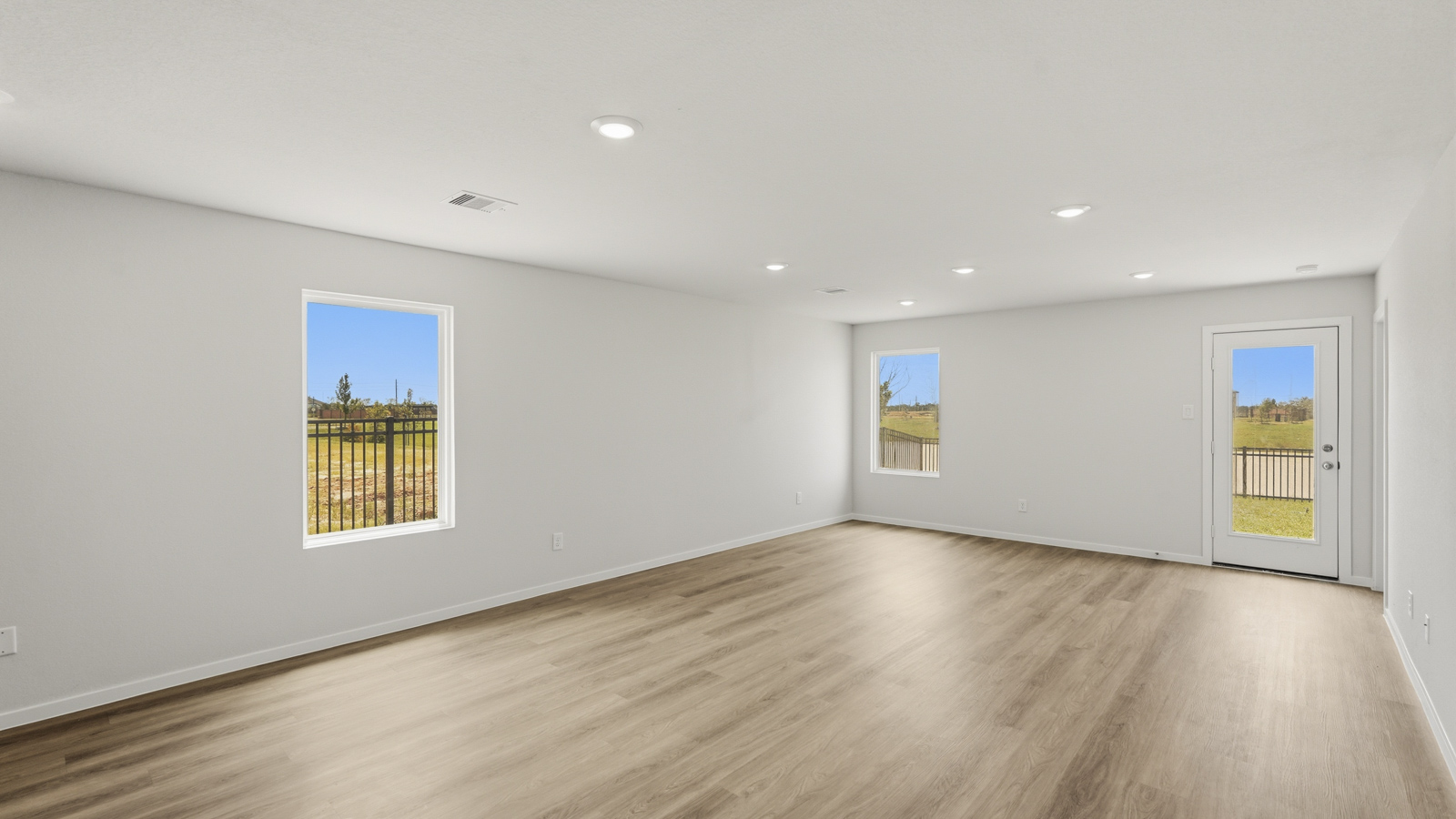 open concept living and dining area with vinyl flooring, stainless steel appliances, and quartz countertops in Katy, TX