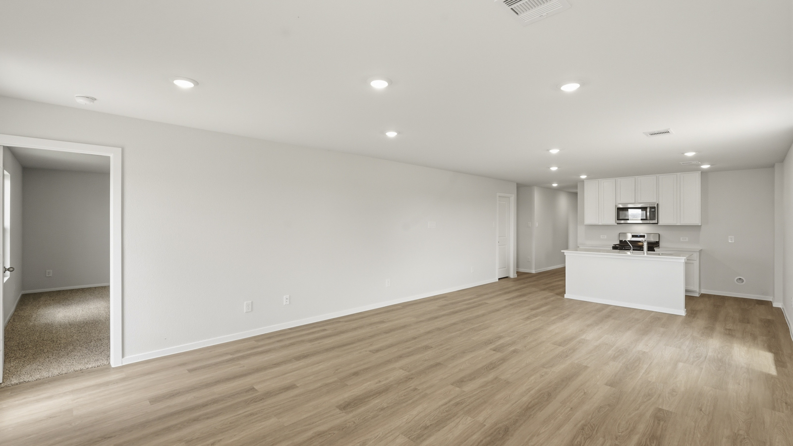 open concept living and dining area with vinyl flooring, stainless steel appliances, and quartz countertops in Katy, TX