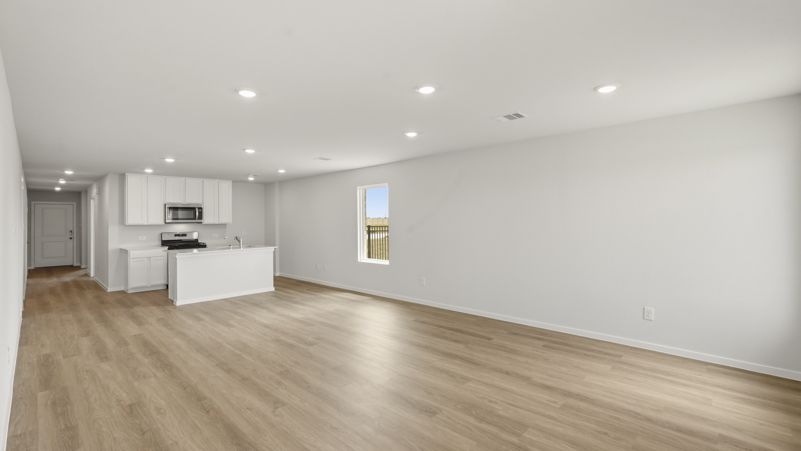 open concept living and dining area with vinyl flooring, stainless steel appliances, and quartz countertops in Katy, TX