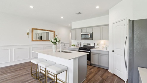 kitchen and dining area with stainless steel appliances, quartz countertops, and vinyl flooring