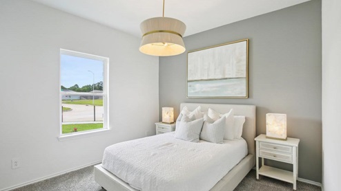 secondary bedroom with carpet flooring and large windows