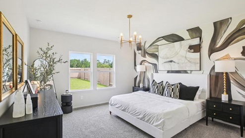 primary bedroom with carpet flooring and large windows