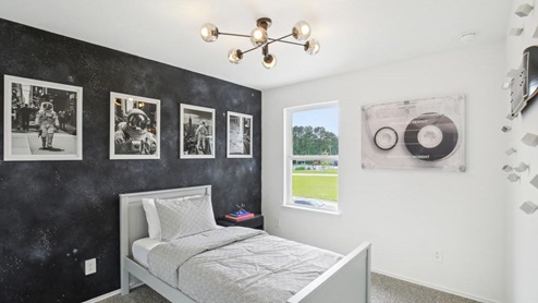 secondary bedroom with carpet flooring and large windows