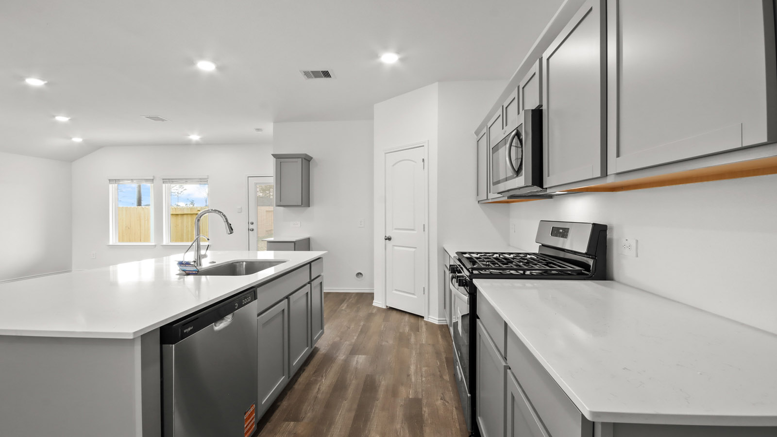 open concept living and dining area with vinyl flooring, quartz counertops, and large windows