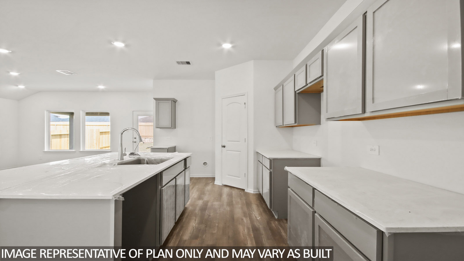 open concept living and dining area with vinyl flooring, stainless steel appliances, and quartz countertops