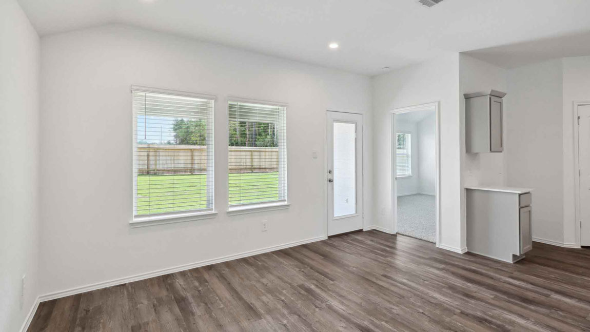 open concept living and dining area with vinyl flooring, large windows, and quartz countertops