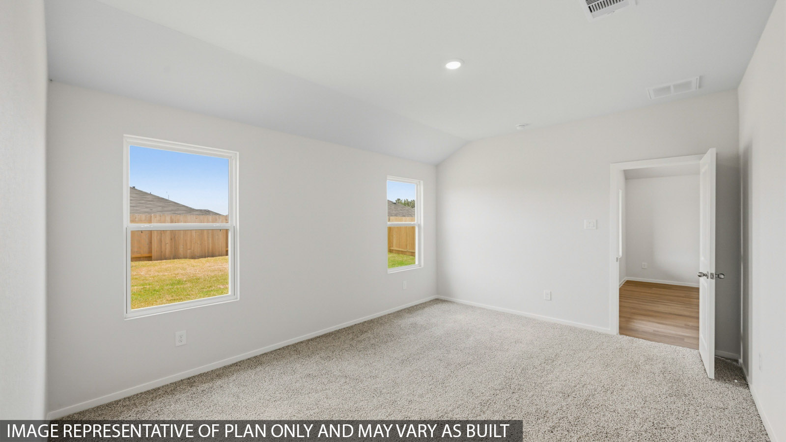 Secondary bedroom with windows, light carpet, and white walls.