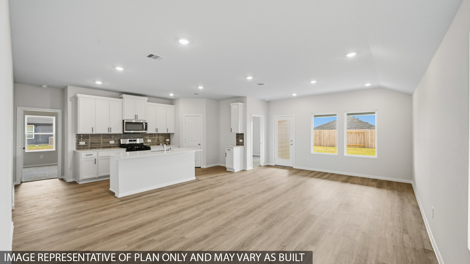Open living room with windows, vinyl wood flooring, and white walls.