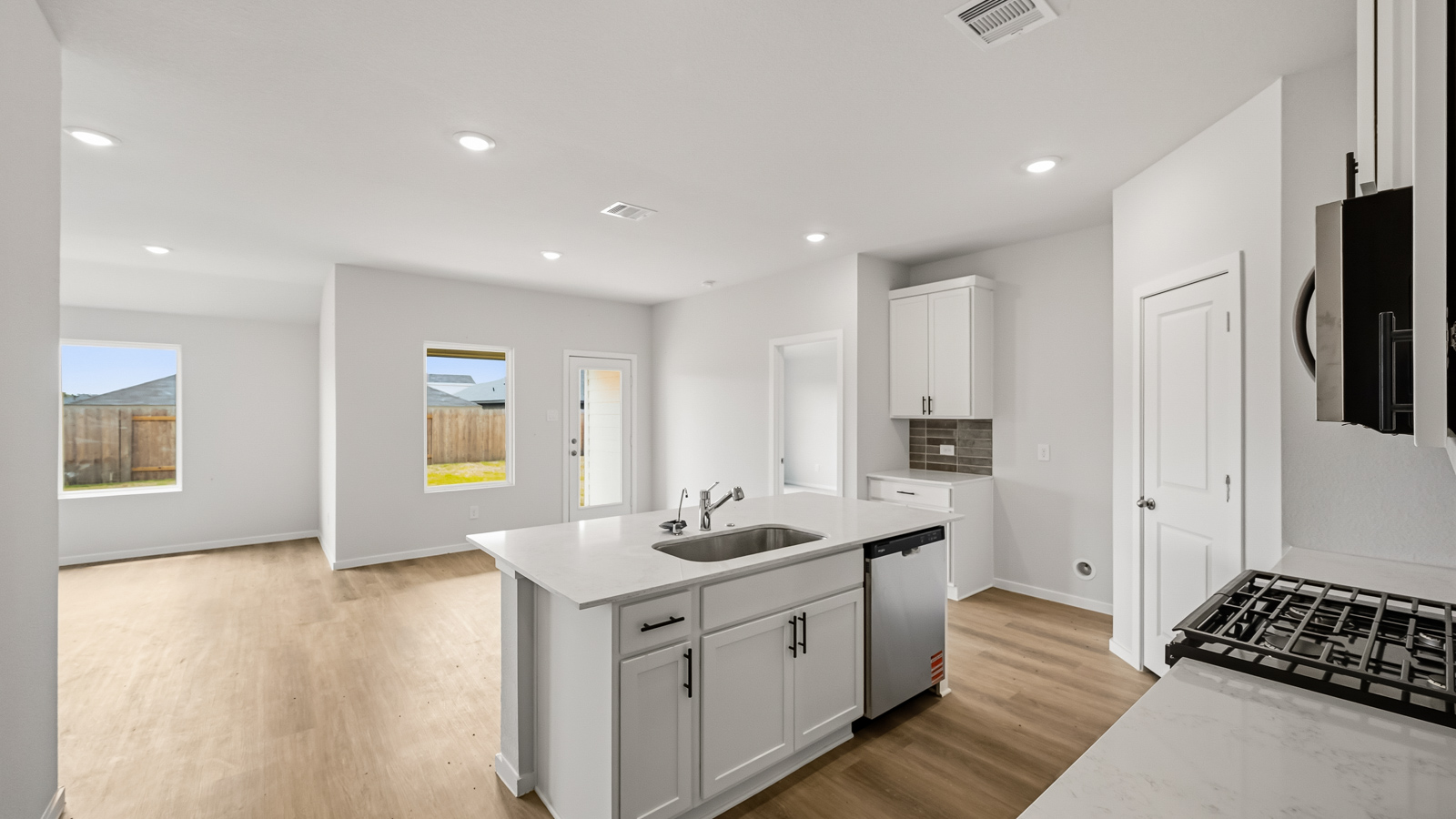 Kitchen with quartz countertops, modern hardware and an island and vinyl floor