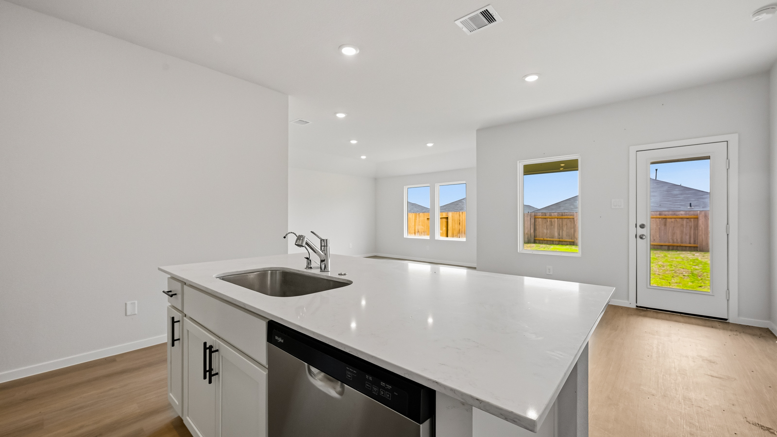 Kitchen with quartz countertops, modern hardware and an island and vinyl floor