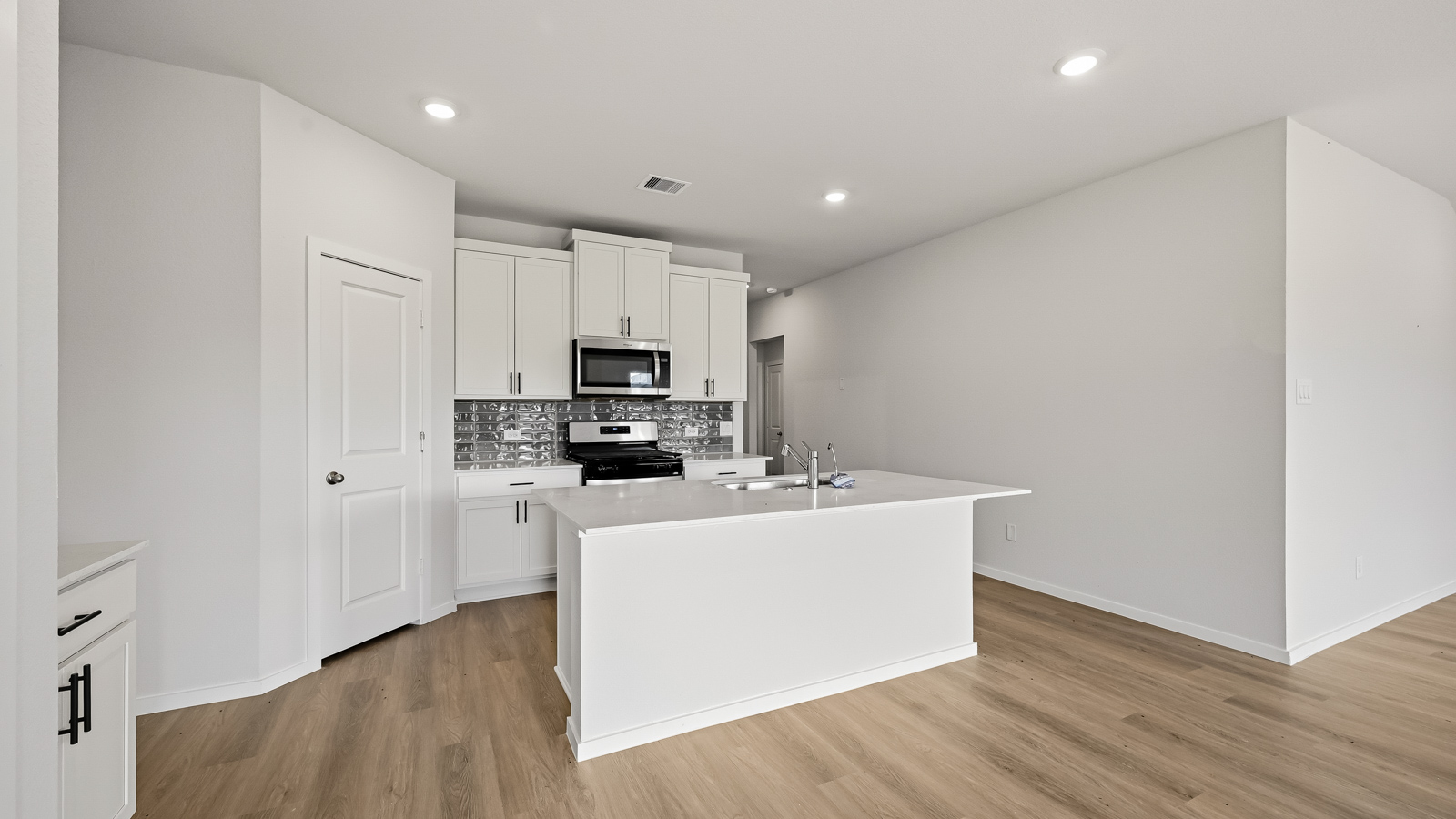 Kitchen with quartz countertops, modern hardware and an island and vinyl floor
