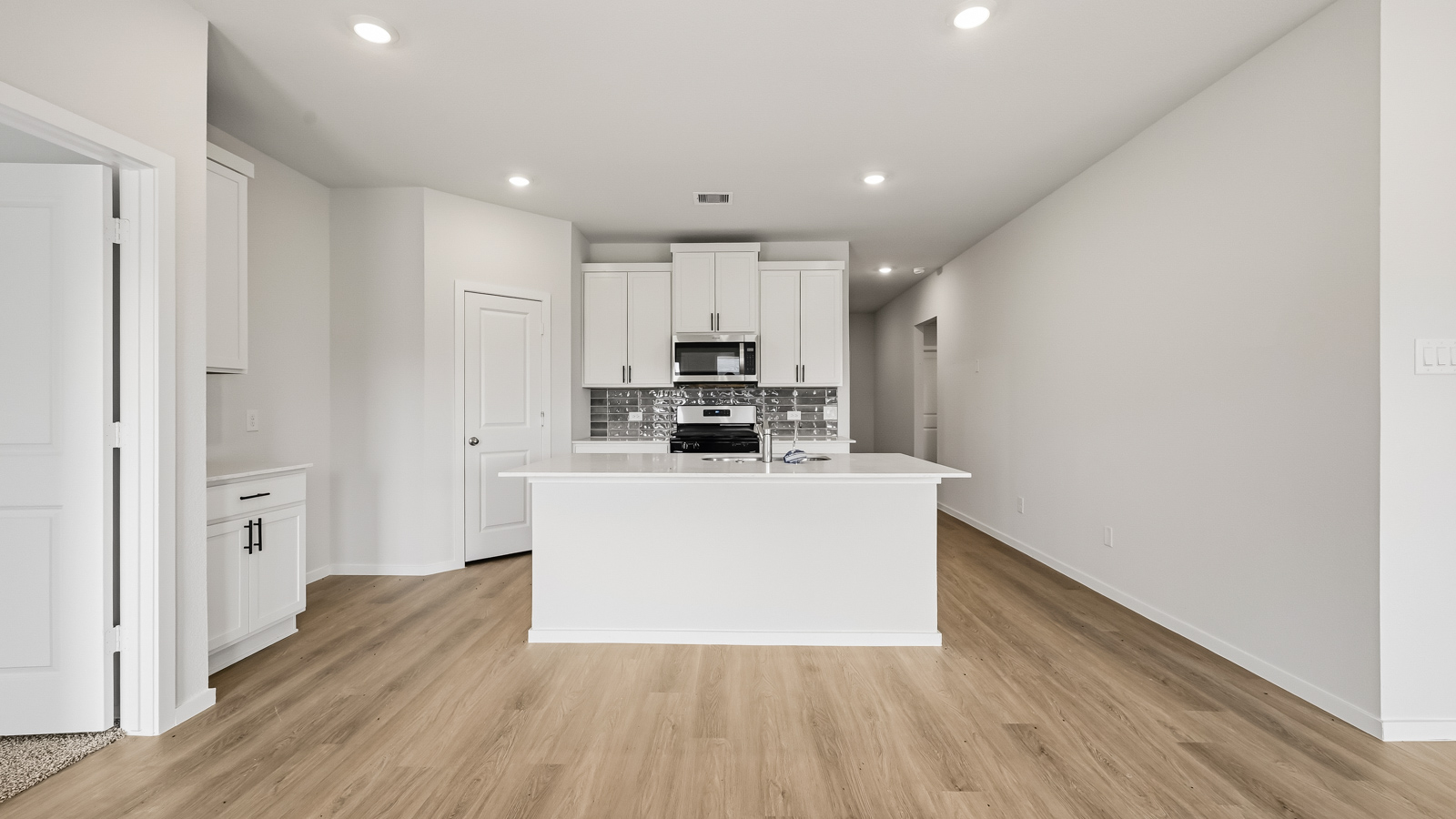 Kitchen with quartz countertops, modern hardware and an island and vinyl floor