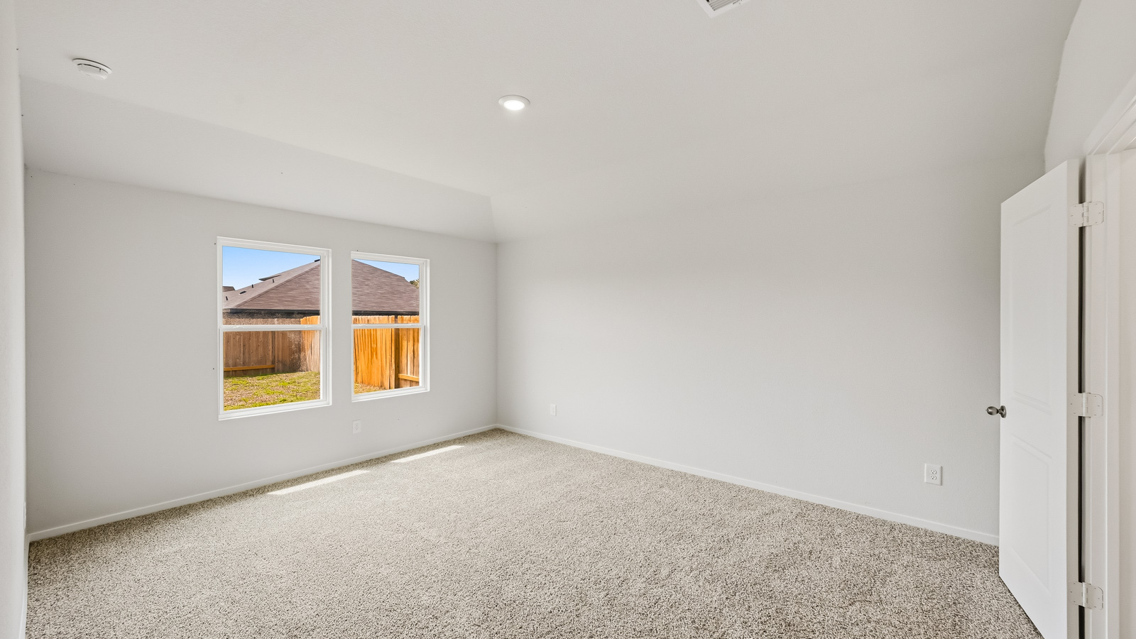 Large Primary bedroom with shag carpet flooring and bright window