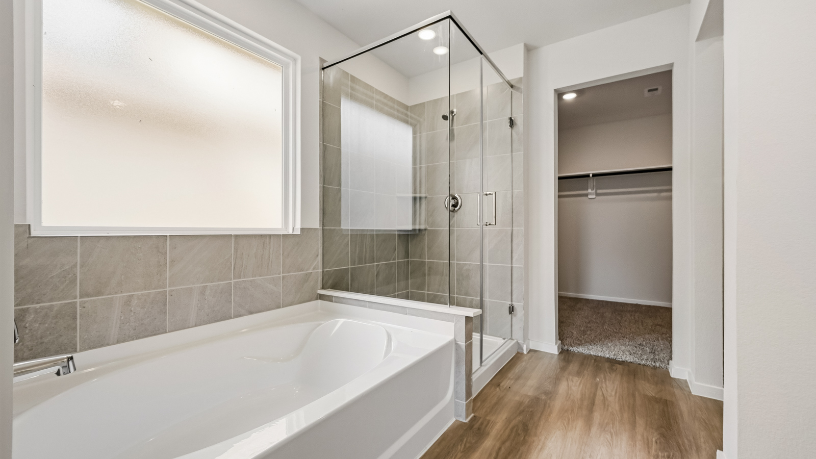 Primary bathroom with soaker tub and tile shower with semi frameless glass in Hockley TX