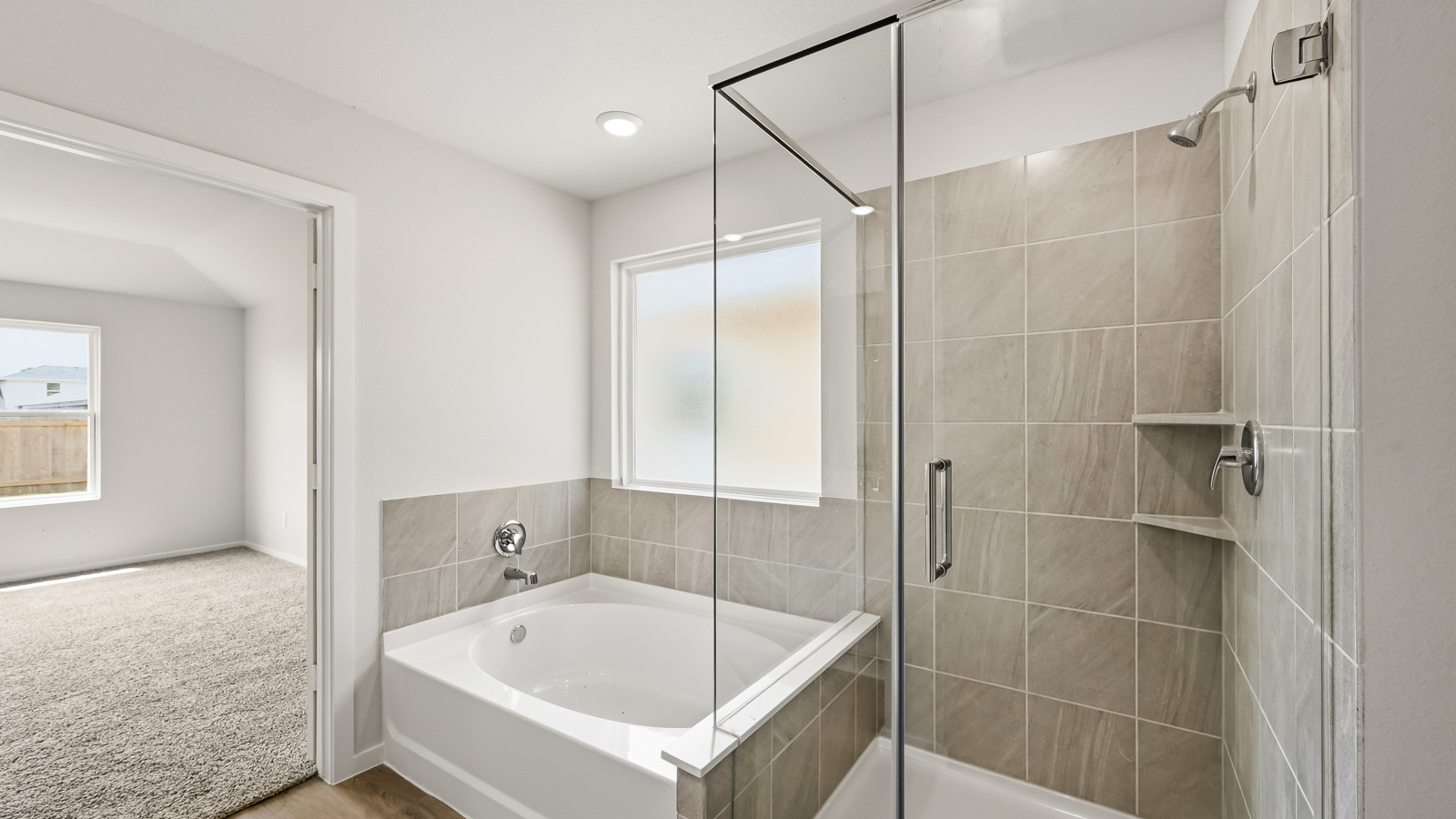 Primary bathroom with soaker tub and tile shower with semi frameless glass in Hockley TX