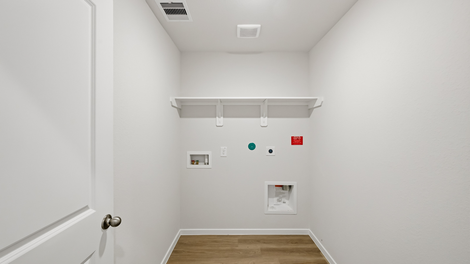Utility room with storage located off the entry hallway and garage door
