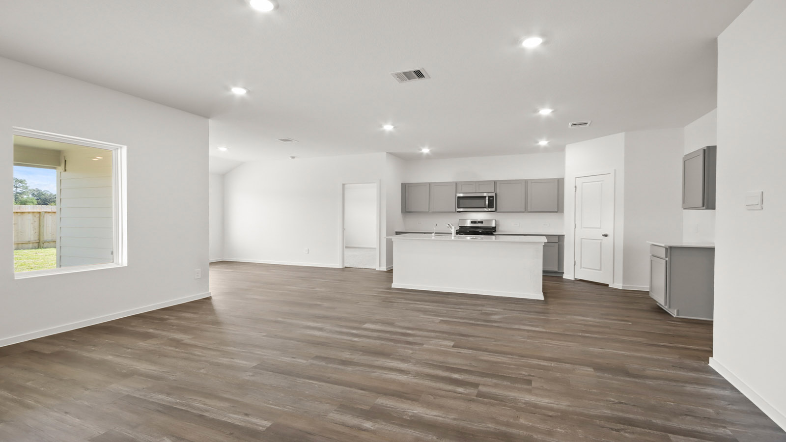 open concept living and dining area with vinyl flooring, quartz countertops, and large windows