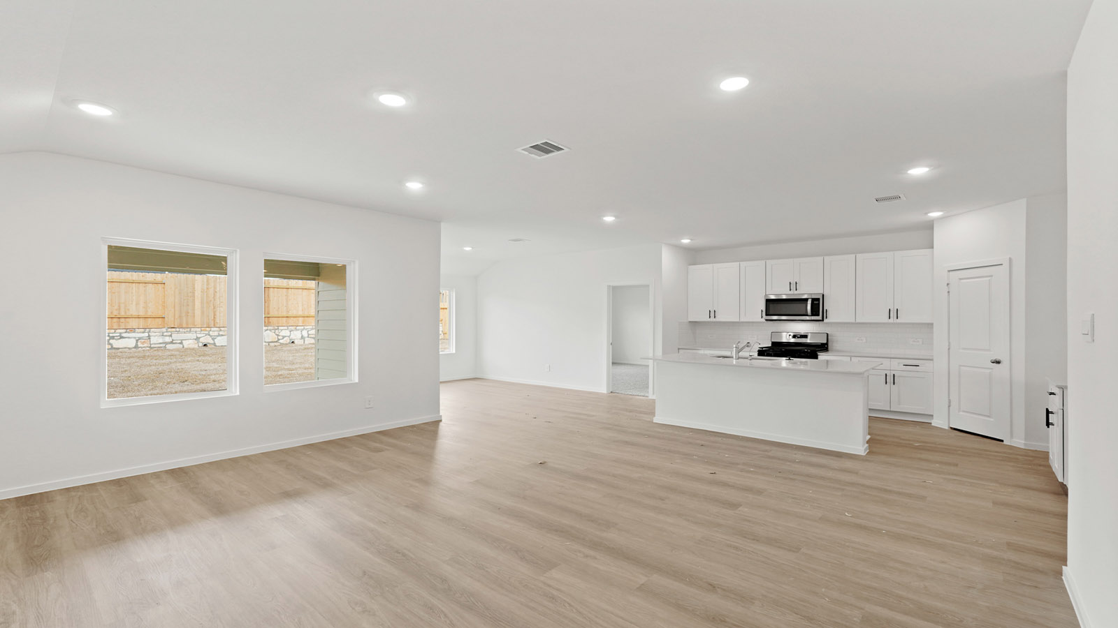 open concept living and dining area with vinyl flooring and quartz countertops