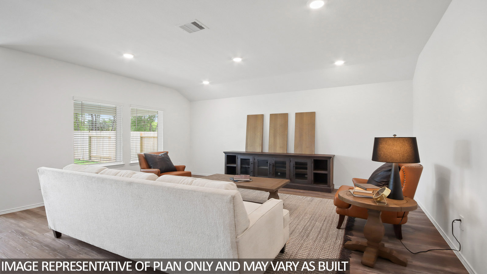 Open living room with windows, white walls, and vinyl wood flooring.