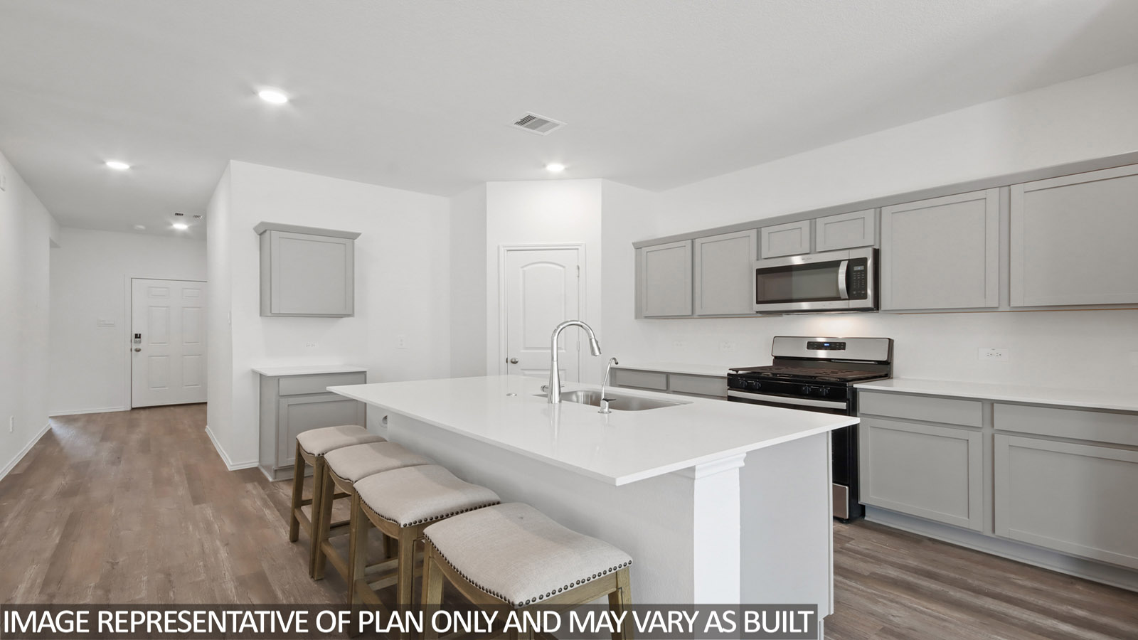 Open kitchen with stainless steel appliances, an island, light gray cabinets, white countertops, white walls, and vinyl wood flooring.