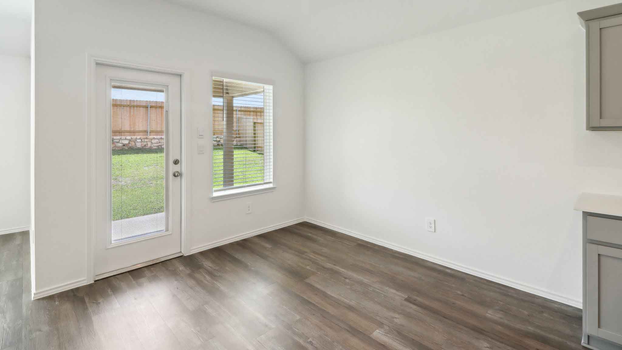 open concept living and dining area with vinyl flooring, quartz countertops, and stainless steel appliances