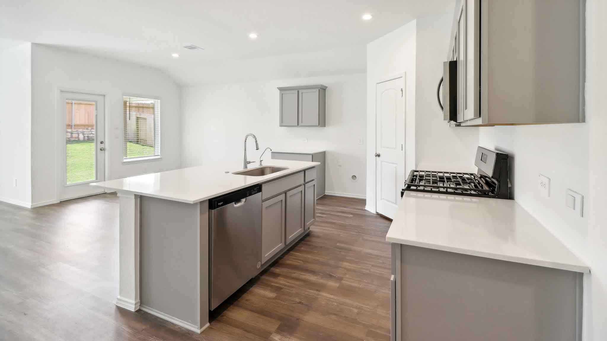 open concept living and dining area with vinyl flooring, quartz countertops, and stainless steel appliances