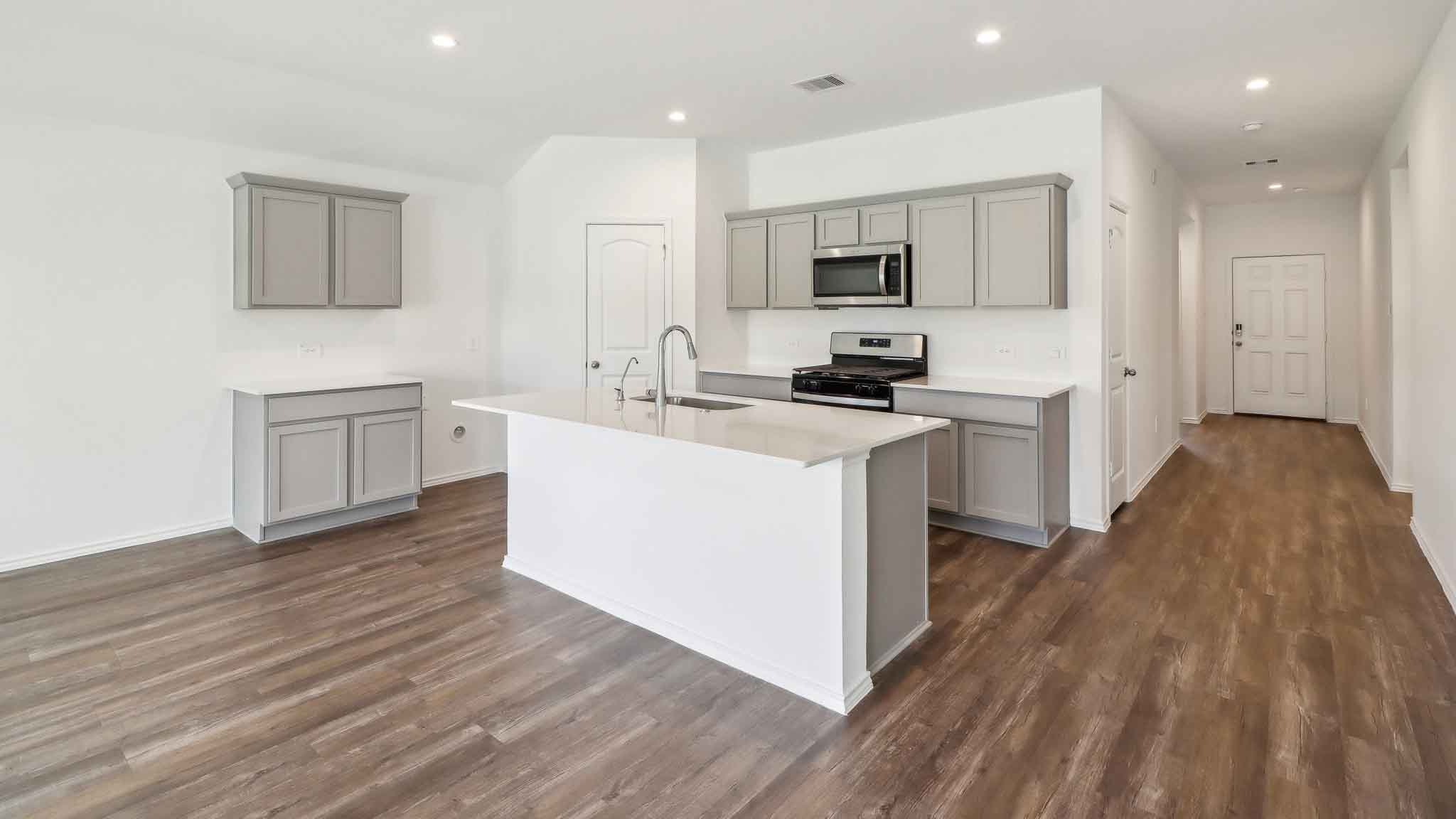 open concept living and dining area with vinyl flooring, quartz countertops, and stainless steel appliances
