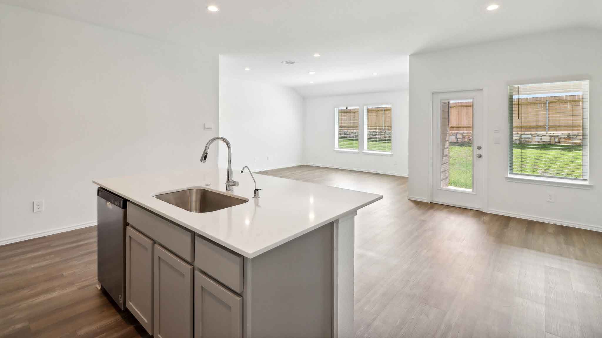 open concept living and dining area with vinyl flooring, quartz countertops, and stainless steel appliances