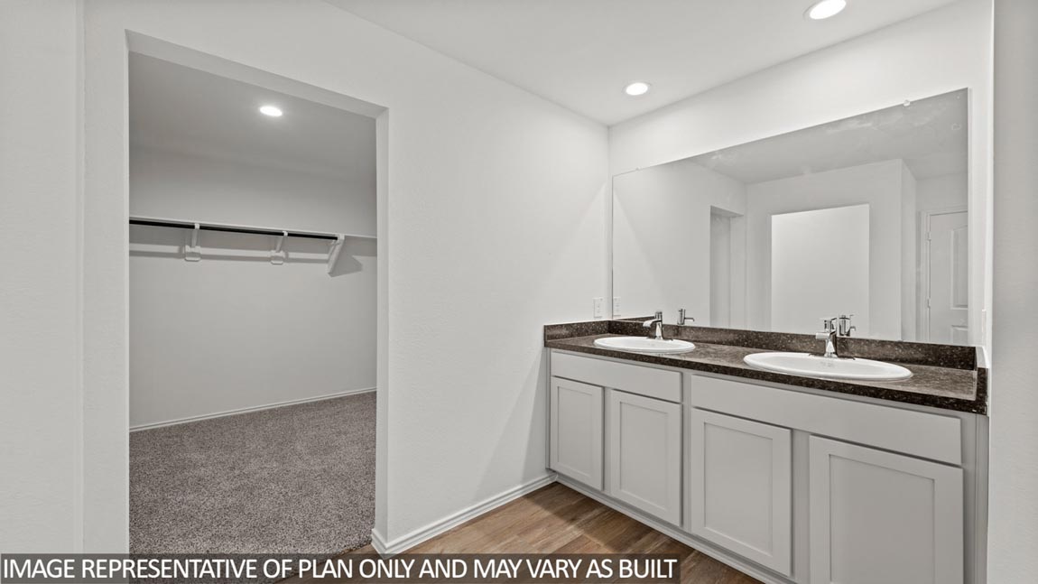 primary bathroom with dual vanities
