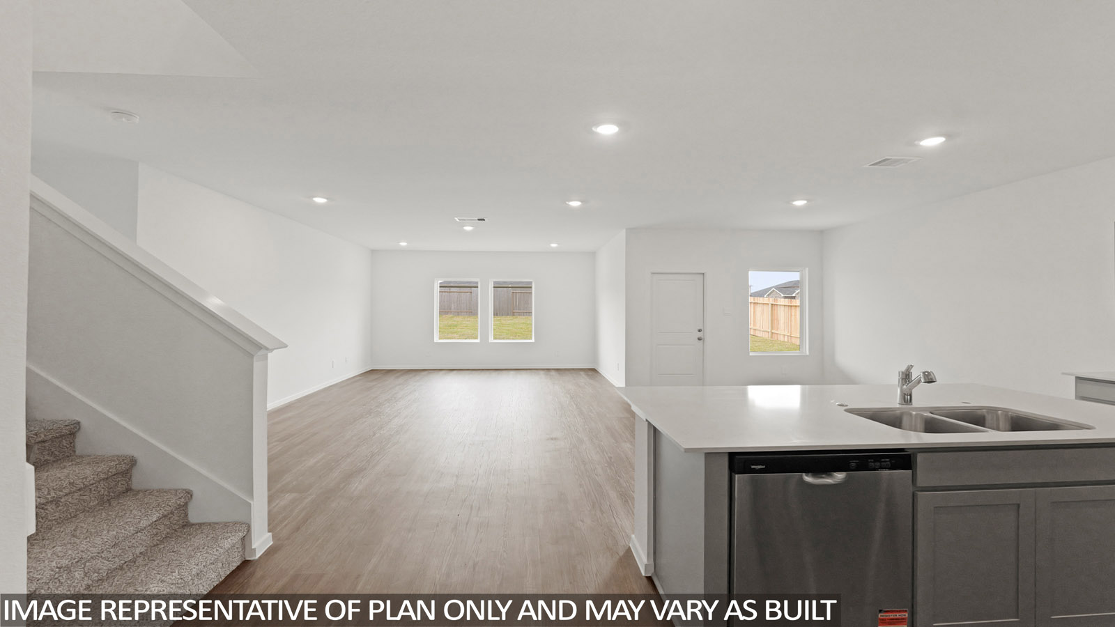 open concept living and dining area with vinyl flooring, quartz countertops, and stainless steel appliances