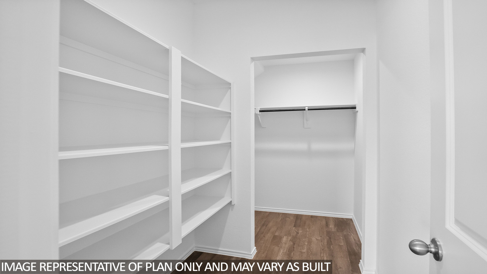 Primary bathroom with a walk-in shower, dual sinks, light gray cabinets, white countertops,vinyl wood flooring, and white walls.