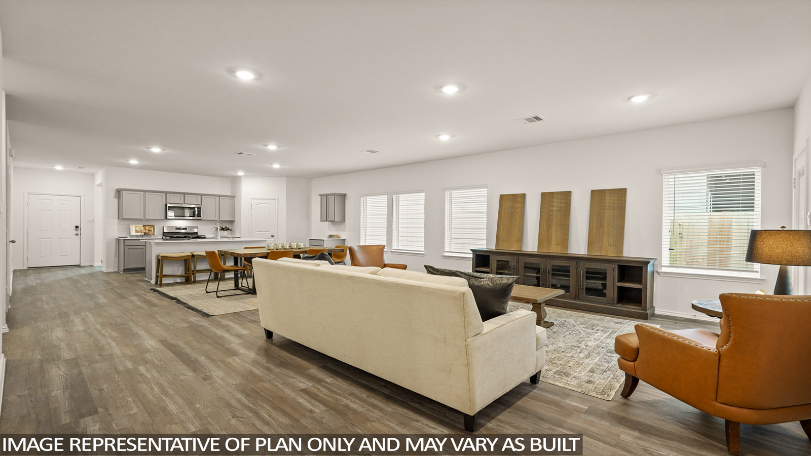 open concept living and dining area with vinl flooring, stainless steel appliances, and quartz countertops in Magnolia, TX