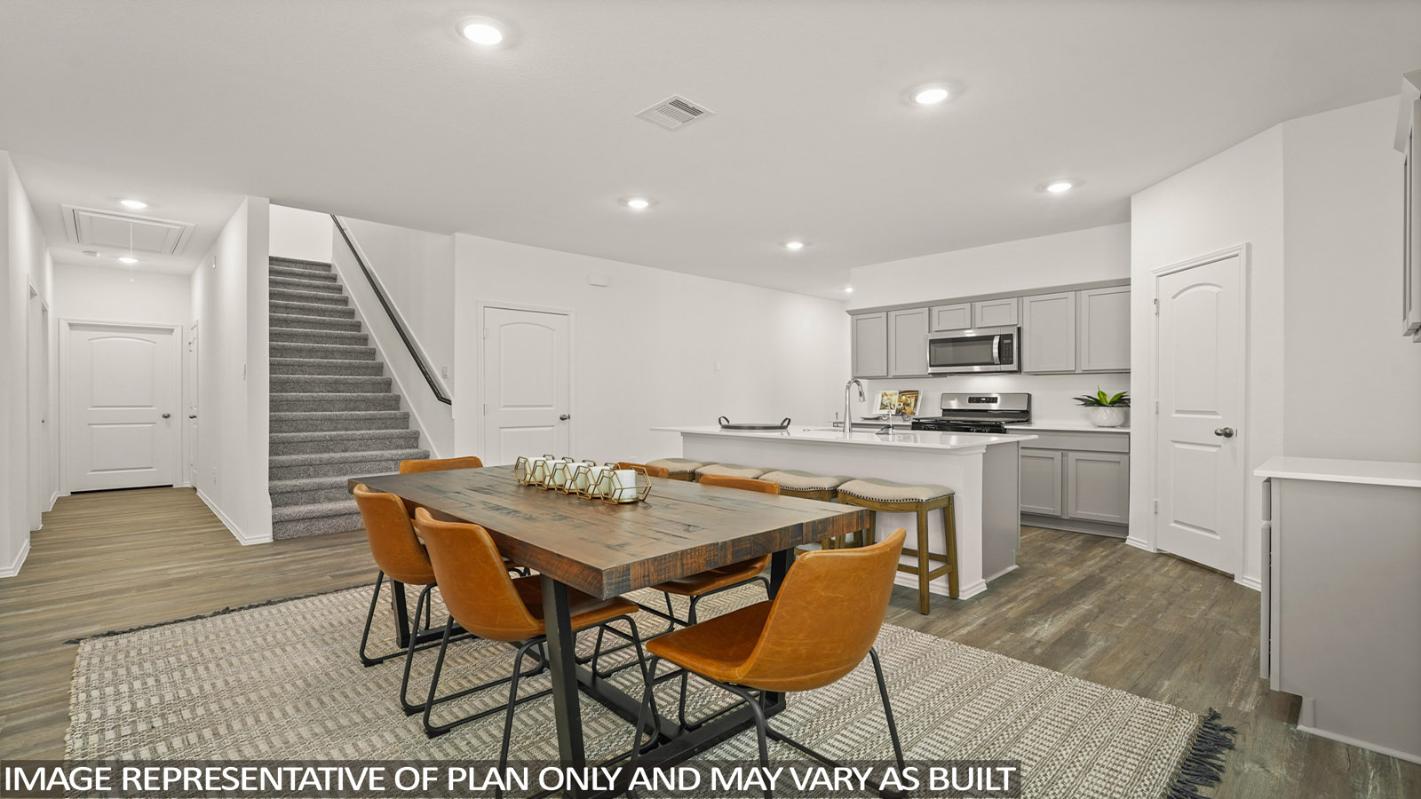 open concept living and dining area with vinl flooring, stainless steel appliances, and quartz countertops in Magnolia, TX