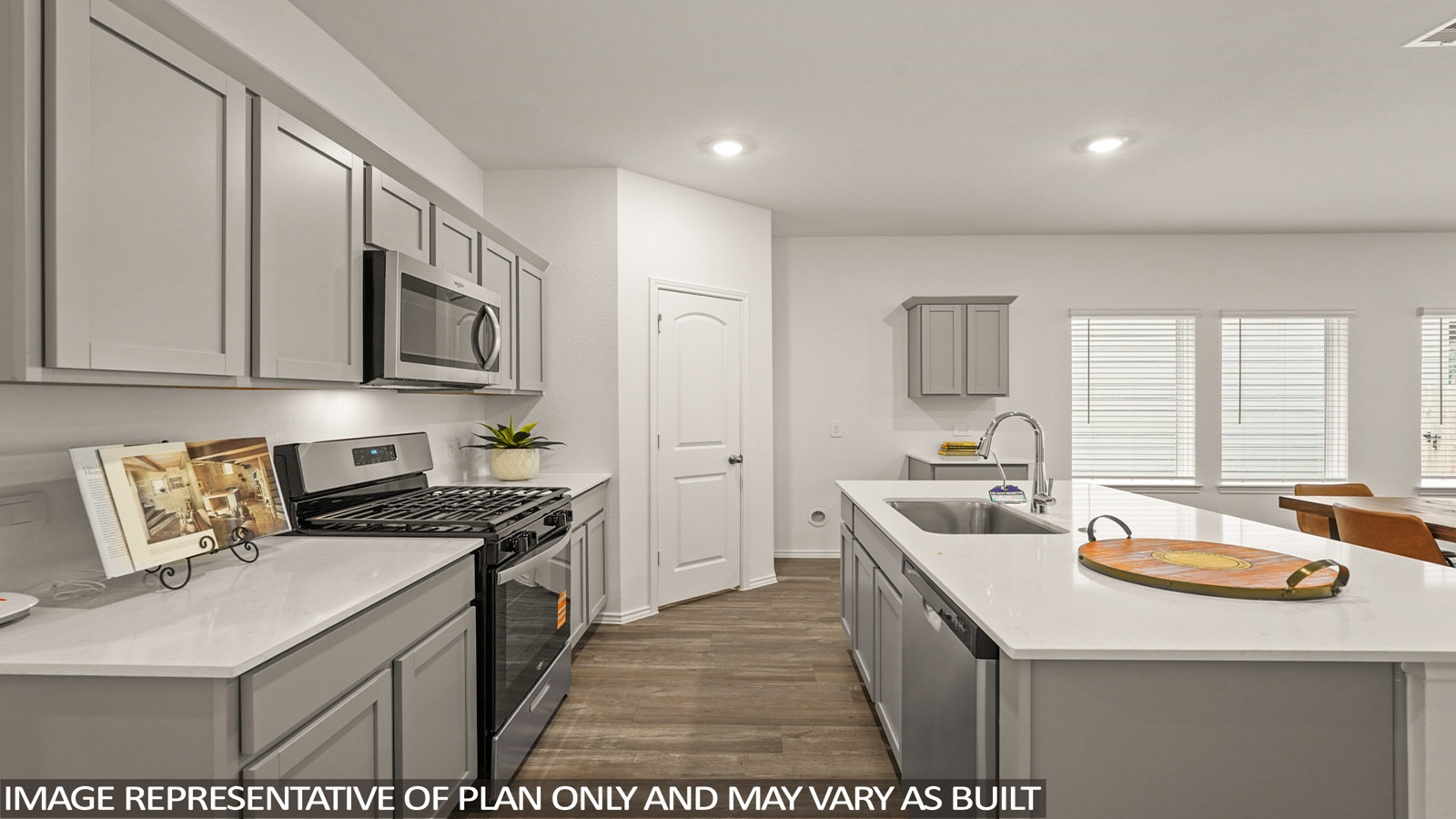 open concept living and dining area with vinl flooring, stainless steel appliances, and quartz countertops in Magnolia, TX