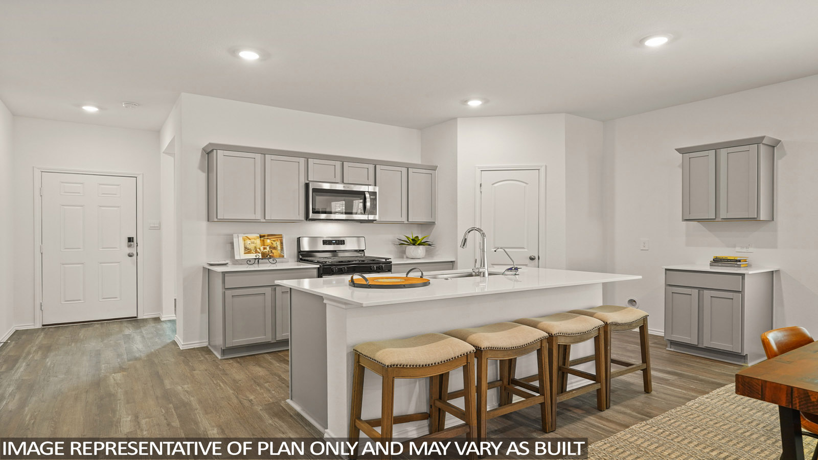 open concept living and dining area with vinl flooring, stainless steel appliances, and quartz countertops in Magnolia, TX