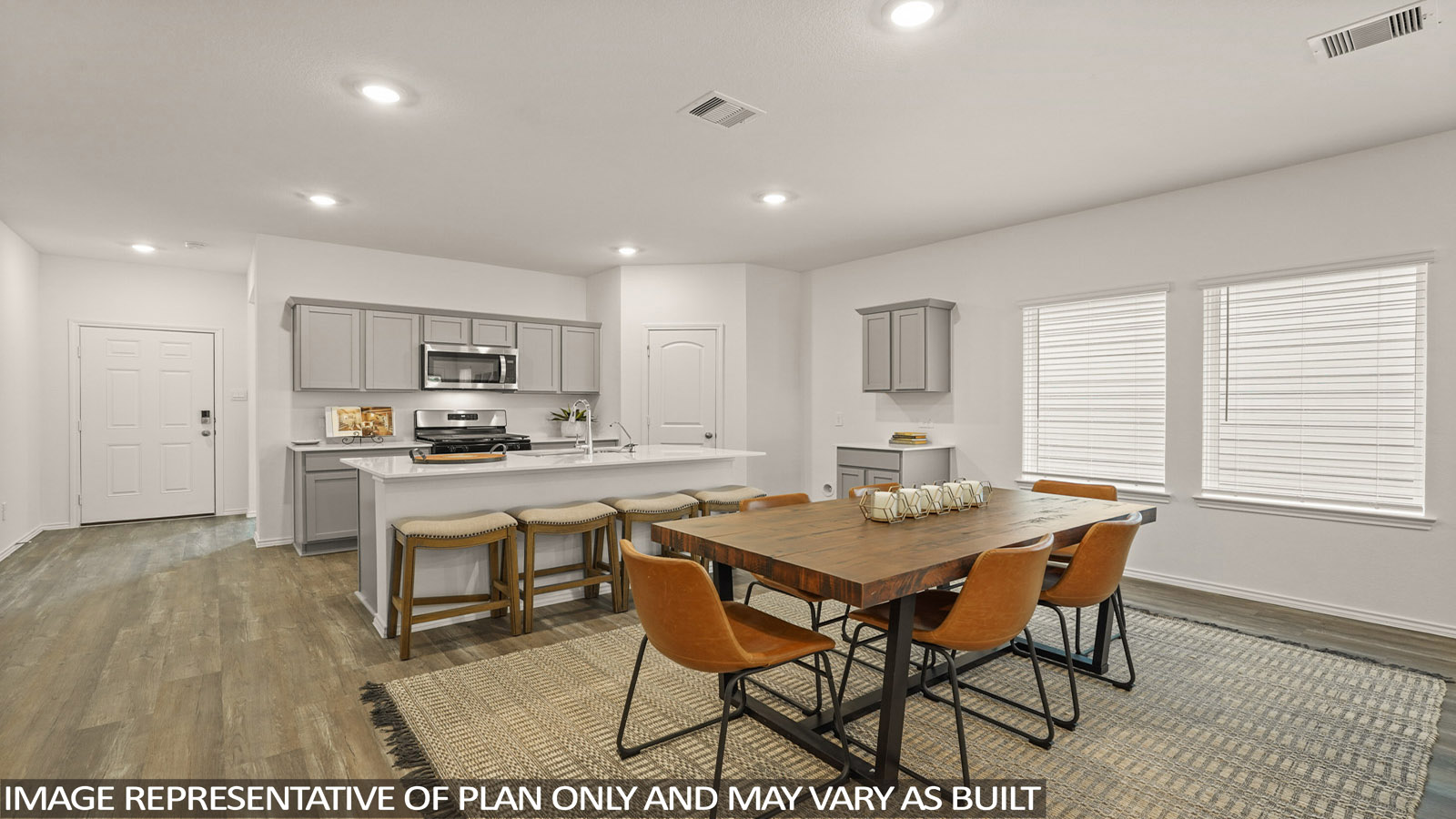 open concept living and dining area with vinl flooring, stainless steel appliances, and quartz countertops in Magnolia, TX