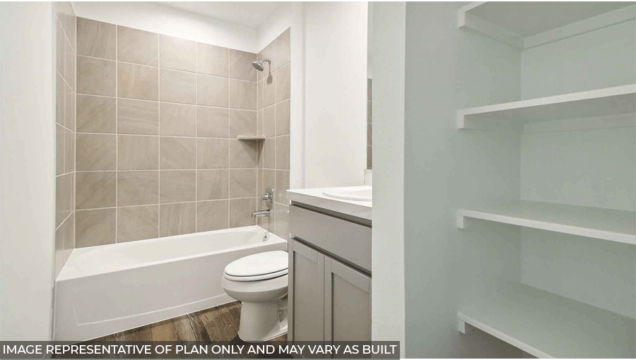 Secondary bathroom with a shower and tub combo, toilet, storage shelves, light gray cabinets, white walls, and vinyl wood flooring,