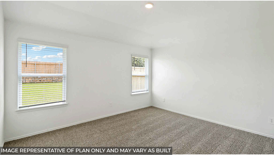 Primary bedroom with windows, light carpet, and white walls.